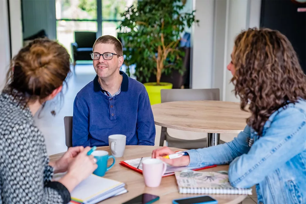 Intervenants sociaux qui discutent avec un bénéficiaire.